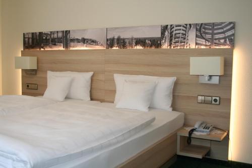 a bedroom with a white bed and a telephone at Hotel Sonnenhof in Bad Wildbad
