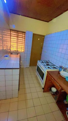 a kitchen with a stove and a microwave in it at AG appart'hôtel villas in Ouagadougou