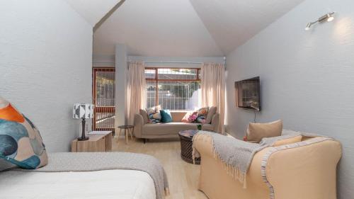 una sala de estar con una cama y un sofá en House on Westcliff, en Hermanus