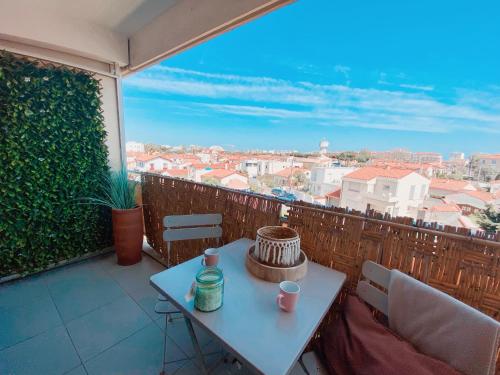 a table on a balcony with a view of a city at Studio calme -304- in Canet-en-Roussillon