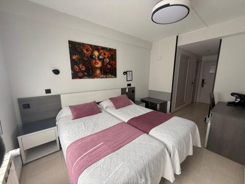 a bedroom with a large bed with a painting on the wall at Plaza Santander in Santander