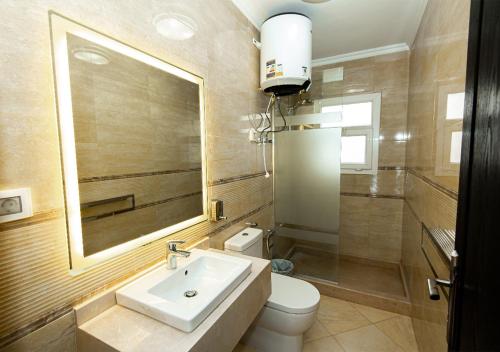 Un baño con lavabo, inodoro y espejo. en Luxury 3BR Apartment Pool View, en El Cairo