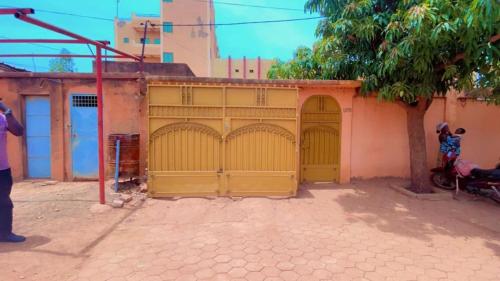 a yellow garage with two doors on a building at AG appart'hôtel villas in Ouagadougou