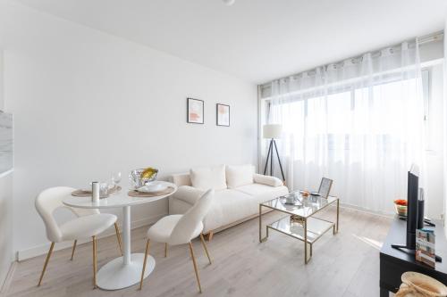 un salon blanc avec un canapé blanc et une table dans l'établissement Asirem - Pied de métro dans le 7ème, à Lyon