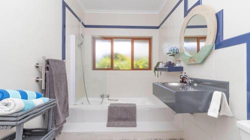 Un baño con lavabo, ducha y bañera. en House on Westcliff, en Hermanus