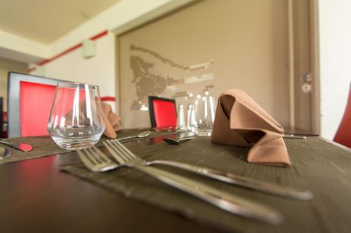 a table with a fork and a wine glass on it at Hotel Inn Design Sedan in Sedan