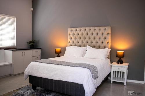 een slaapkamer met een groot bed met twee lampen bij NamaStay in Kaapstad