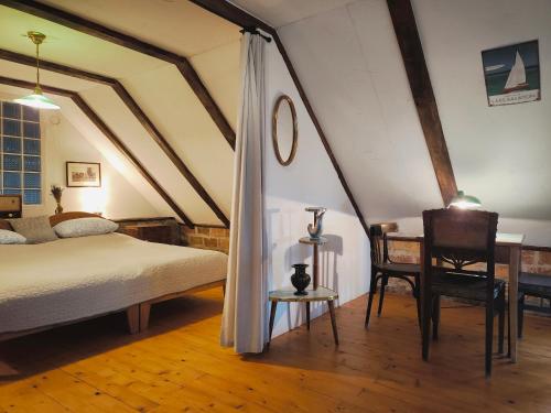 a bedroom with a bed and a table and a chair at Henye Vintage Home a Káli-medencében in Balatonhenye
