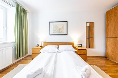 a bedroom with a white bed and two night stands at Genuine Vienna Home by JR City Apartments in Vienna