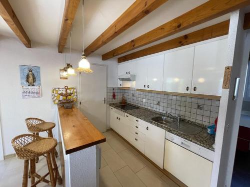une cuisine avec des armoires blanches et un comptoir en bois dans l'établissement Charmante Villa 6 Pers. avec Jardin, Terrasse et Parking à Vieux Boucau - FR-1-379-116, à Soustons