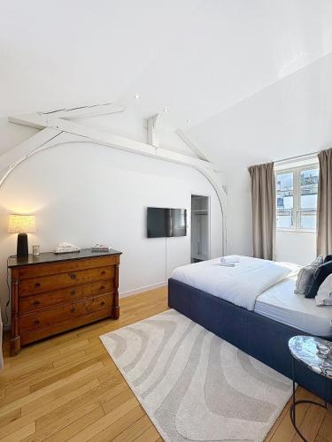 - une chambre avec un lit, une commode et une télévision dans l'établissement So Guest- Pépite de charme proche cathédrale, climatisation Parking, à Reims