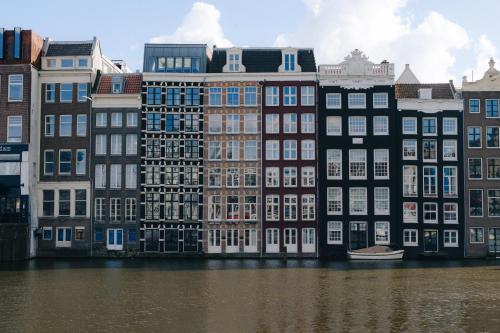 a group of buildings next to a body of water at THIS HO(S)TEL in Amsterdam