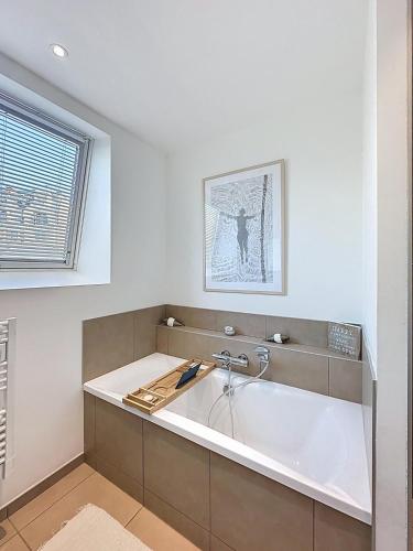 La salle de bains est pourvue d'une baignoire et d'un lavabo. dans l'établissement So Guest- Pépite de charme proche cathédrale, climatisation Parking, à Reims