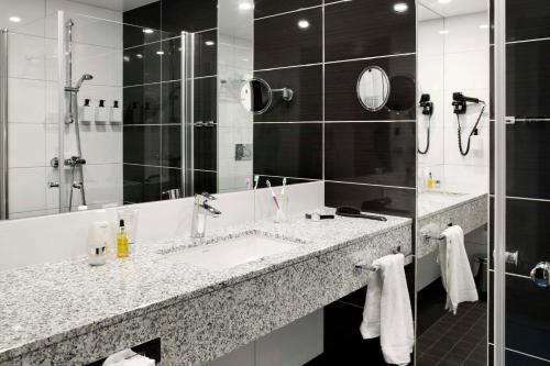a bathroom with two sinks and a shower at Scandic Havet in Bodø
