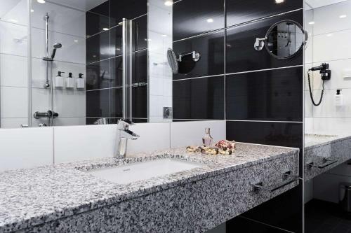 a bathroom with a sink and a shower at Scandic Havet in Bodø