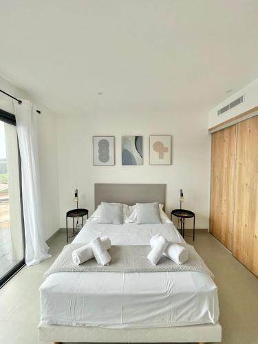 une chambre blanche avec un grand lit avec des oreillers blancs dans l'établissement Villa vue montagne - 8 pers, à Sotta