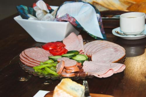 a plate of meat and vegetables on a table at The Residence at Villa Wiese in Swakopmund