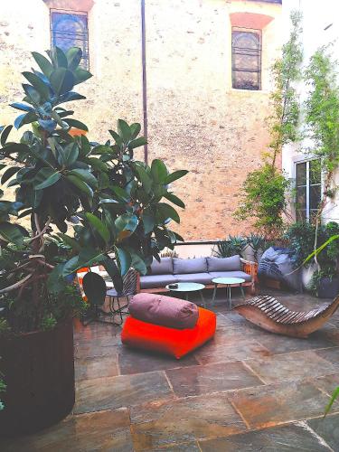 une terrasse avec un canapé, un oreiller et des plantes dans l'établissement Chambres de charme au coeur de la citadelle de BASTIA, à Bastia