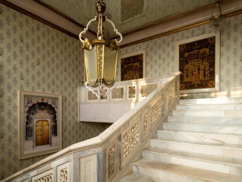 a chandelier hangs over a staircase in a house at Rajmahal Palace RAAS in Jaipur