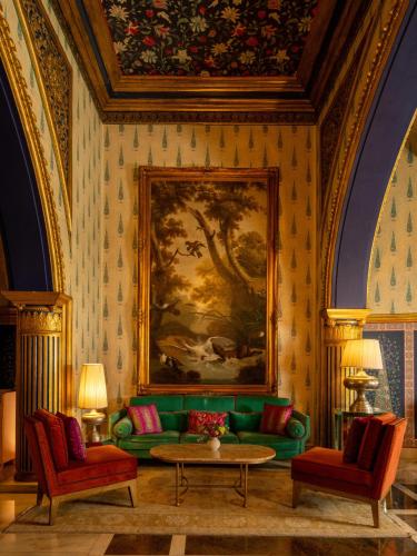 a living room with a green couch and a painting at Rajmahal Palace RAAS in Jaipur