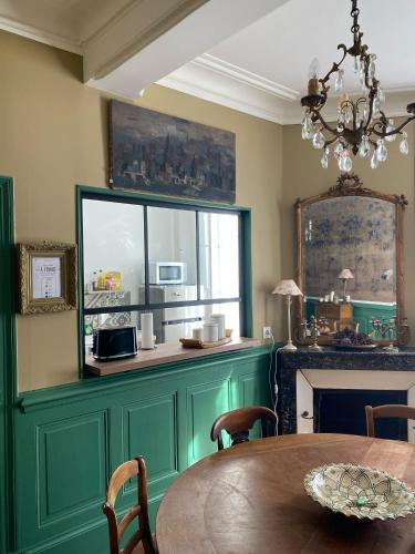 une salle à manger avec une table et un lustre dans l'établissement La Maison Broc'Art, à Auxerre