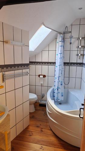 La salle de bains est pourvue d'une grande baignoire et de toilettes. dans l'établissement Gite Petite Florence, à Châteauneuf-du-Faou