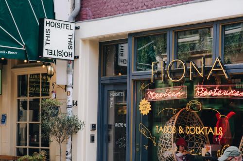 a store with a sign in the window of a store at THIS HO(S)TEL in Amsterdam