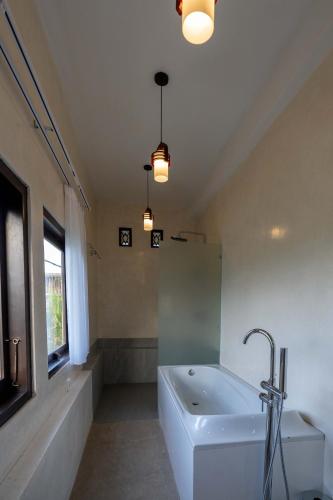 a large bathroom with a tub and a sink at Place of Power in Blahbatu