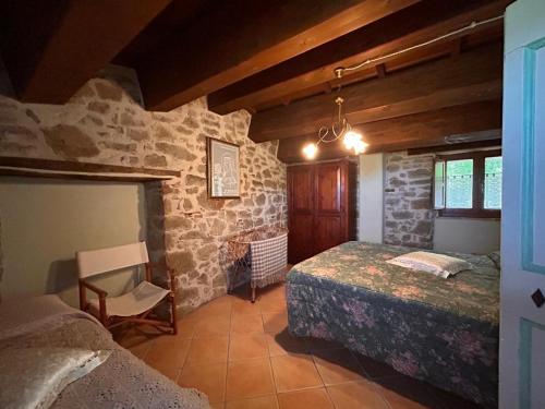 a bedroom with two beds and a stone wall at La casetta nel bosco in Pedana