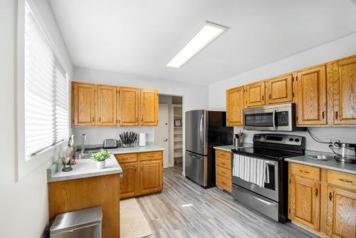 a kitchen with wooden cabinets and stainless steel appliances at Beautiful Home In A Prime Location in Winnipeg