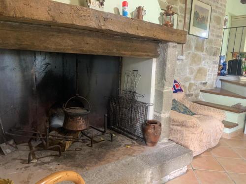 a living room with a stone fireplace with a couch at La casetta nel bosco in Pedana