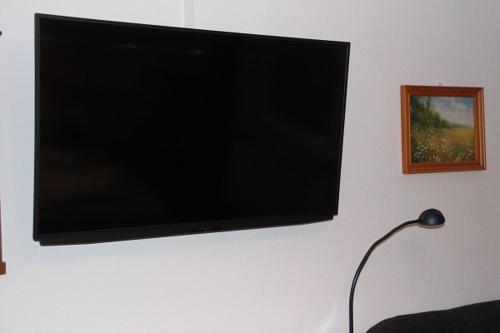 a flat screen tv hanging on a wall at Erwachsenen Aparthotel Naturidyll - Der Wieserhof in Bad Füssing