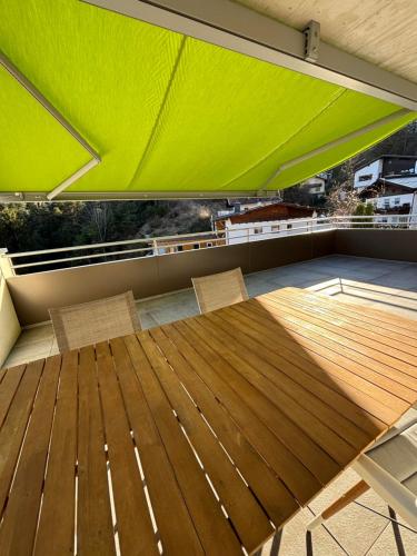 a balcony with a green roof with a table and chairs at Panorama Apartment Imst in Imst