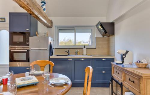 une cuisine avec des placards bleus et une table en bois dans l'établissement 2 Bedroom Gorgeous Home In Offranville, à Offranville