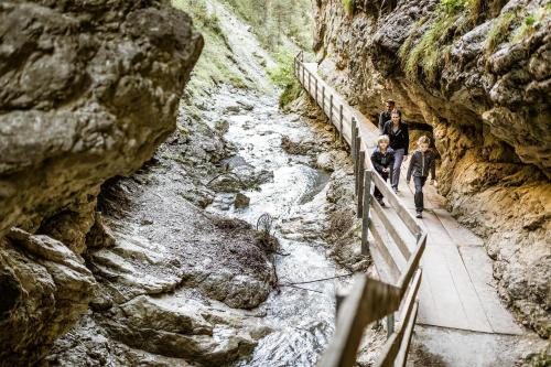 a group of people walking over a bridge over a river at Panorama Apartment Imst in Imst