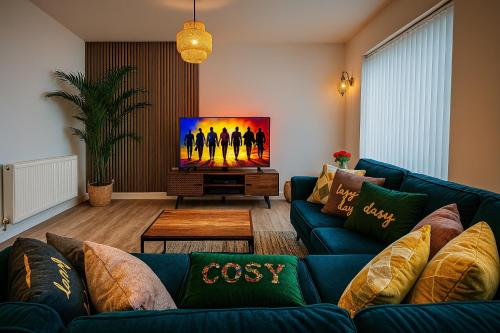 a living room with a blue couch and a flat screen tv at Modern Flat in Glasgow City FREE Parking & Wifi in Glasgow