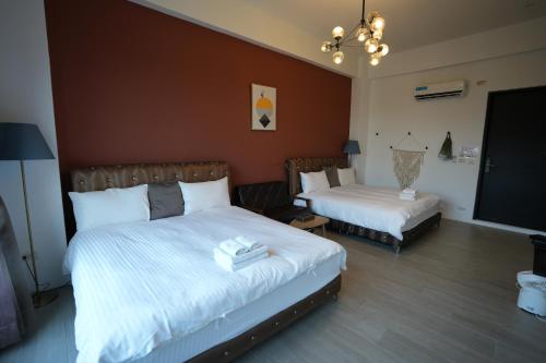 a bedroom with two beds and a flat screen tv at Easyinn in Hengchun