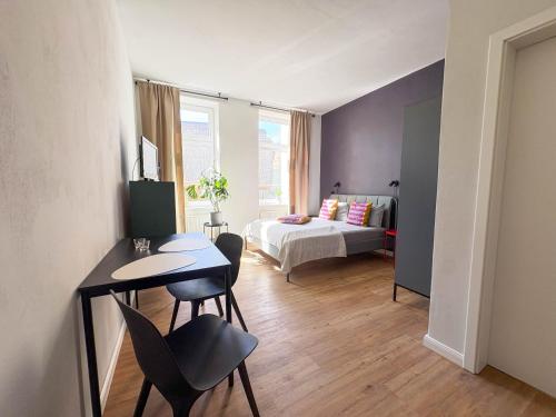 a bedroom with a bed and a table and chairs at Studios am Hafen in Stralsund
