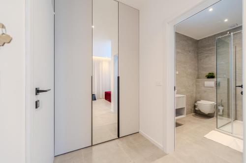 a bathroom with a toilet and a glass door at Kolovare Luxury Rooms in Zadar