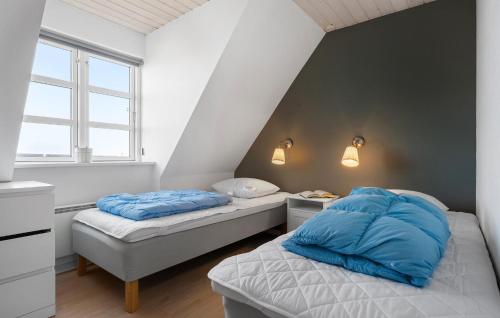 two beds with blue pillows in a small room at Three-Bedroom Apartment Karrebæksminde With Sea View 03 in Karrebæksminde