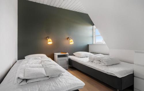 two beds in a room with two lamps on the wall at Three-Bedroom Apartment Karrebæksminde With Sea View 03 in Karrebæksminde