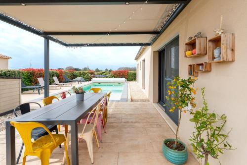 un patio avec une table et des chaises et une piscine dans l'établissement Lou Pitchou Carri, à Richerenches