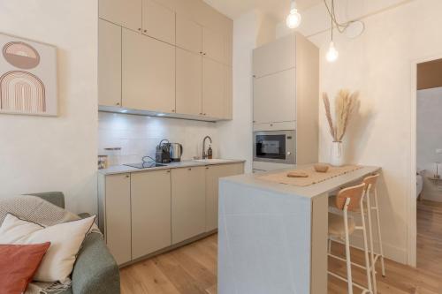 une cuisine et un salon avec des placards blancs et un comptoir dans l'établissement Hypercentre - Le Balcon des Pyrénées, à Pau