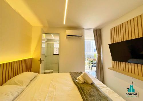 a bedroom with a bed with a television and a bathroom at Aquarius Style by Holiday Stays in Fortaleza