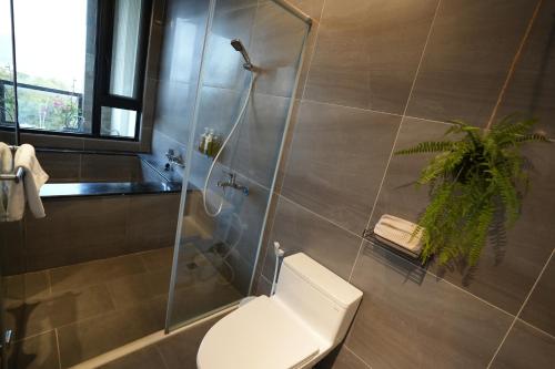 a bathroom with a toilet and a glass shower at Easyinn in Hengchun