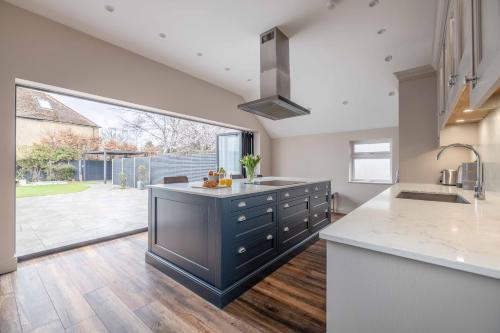 a kitchen with a sink and a large window at FAMILY FRIENDLY ESCAPE IN ETON, COUNTRYSIDE VIEWS with Hot Tub - By Tempstay in Eton