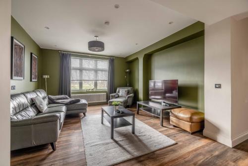 a living room with a couch and a tv at FAMILY FRIENDLY ESCAPE IN ETON, COUNTRYSIDE VIEWS with Hot Tub - By Tempstay in Eton