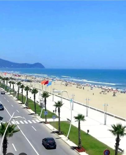 a view of a beach with palm trees and a road at Abdel in Martil