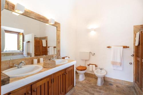 une salle de bain avec deux lavabos et un WC et un miroir dans l'établissement True Local Village, à Loulé