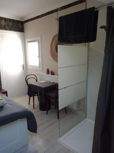 a bedroom with a glass shower and a table at La Maison in Mirebeau-sur-Bèze